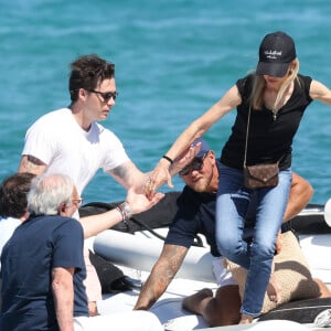 Brooklyn Beckham et sa femme Nicola Peltz, accompagnée de ses parents, arrivent au Club 55 à Saint-Tropez, le 27 juillet 2023. Paré de claquettes-chaussettes, le fils de D.Beckham et V.Beckham, prend sa douce dans ses bras pour débarquer sur la plage. Il a même pris le soin de tendre la main à ses beaux-parents, Nelson et Claudia Heffner Peltz, pour les aider à quitter le Zodiac. 