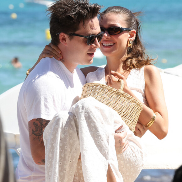 Brooklyn Beckham et sa femme Nicola Peltz, accompagnée de ses parents, arrivent au Club 55 à Saint-Tropez, le 27 juillet 2023. Paré de claquettes-chaussettes, le fils de D.Beckham et V.Beckham, prend sa douce dans ses bras pour débarquer sur la plage. Il a même pris le soin de tendre la main à ses beaux-parents, Nelson et Claudia Heffner Peltz, pour les aider à quitter le Zodiac. 