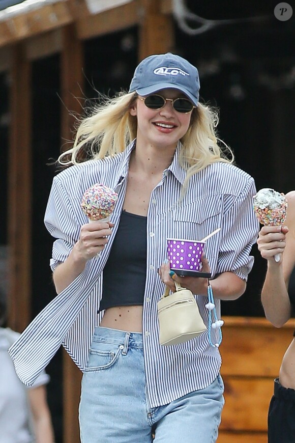 Gigi Hadid mange une glace tout en marchant dans les rues de New York avec une amie, Leah McCarthy. Le 13 avril 2023