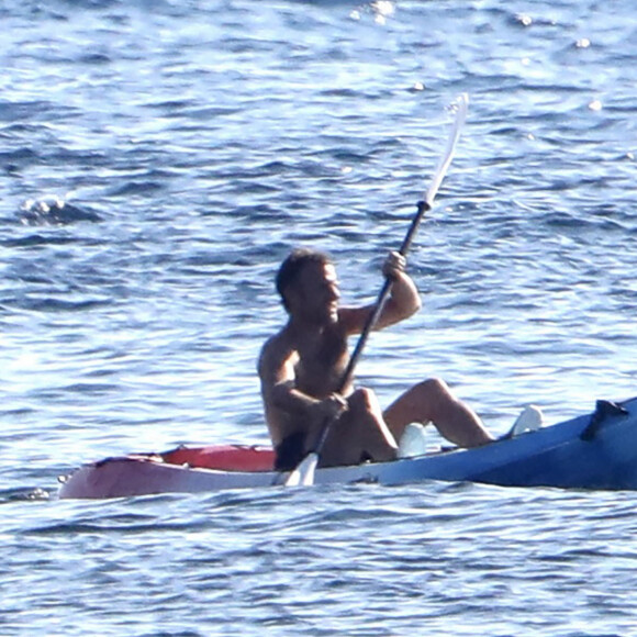 Exclusif - Le président Emmanuel Macron fait du canoë-kayak lors de ses vacances au Fort de Brégançon à Bormes-les-Mimosas le 3 aout 2022. Aux alentours de 18 heures, Emmanuel Macron a été aperçu seul, en maillot de bain noir et torse nu, sur un canoë bleu-blanc-rouge. Il s'est offert un court aller-retour d'une vingtaine de minutes, suivi par un agent de sécurité, lui aussi en canoë. © Luc Boutria/Nice-Matin/Bestimage