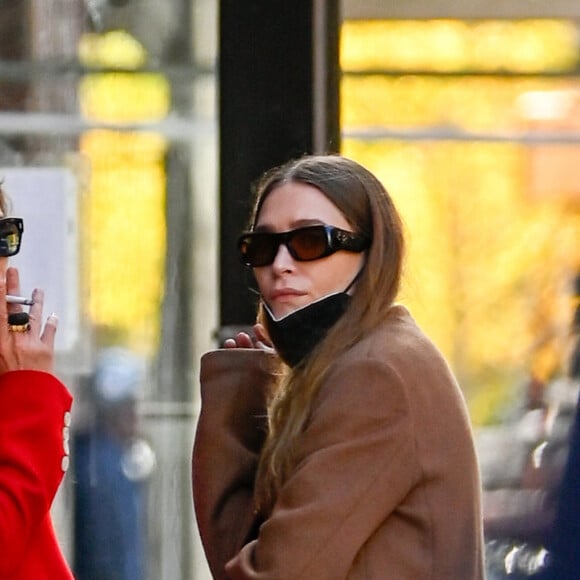 Exclusif - Mary-Kate Olsen et Ashley Olsen sortent pour une pause cigarette à New York City, New York, Etats-Unis, le 22 octobre 2021. 