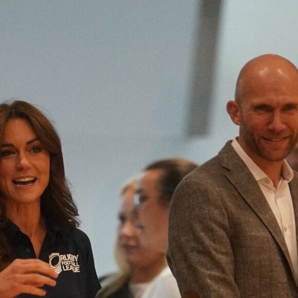 Et quelqu'un l'a prise par la taille, la faisant sursauter ! 
Catherine (Kate) Middleton, princesse de Galles, patronne de la Rugby football League, lors d'une visite au centre sportif Allam de l'Université de Hull pour participer à une journée d'inclusion de la Rugby League organisée par la Rugby football League Hull FC et l'Université. 