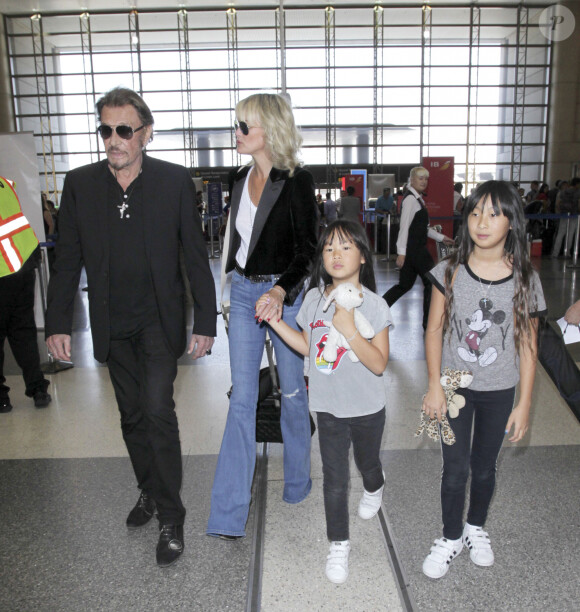 Johnny Hallyday avec sa femme Laeticia et ses enfants Jade et Joy en partance pour Paris arrivent à l'aéroport Lax de Los Angeles le 25 juin 2016. 