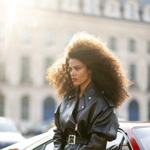 Exclusif - Le mannequin français Tina Kunakey en body et perfecto adossé à une Ferrari 308 lors d'un shooting photo sur la place Vendôme en marge du prêt-à-porter automne-hiver 2023/2024 de la Fashion Week de Paris (PFW) , à Paris, France, le 2 mars 2023. 