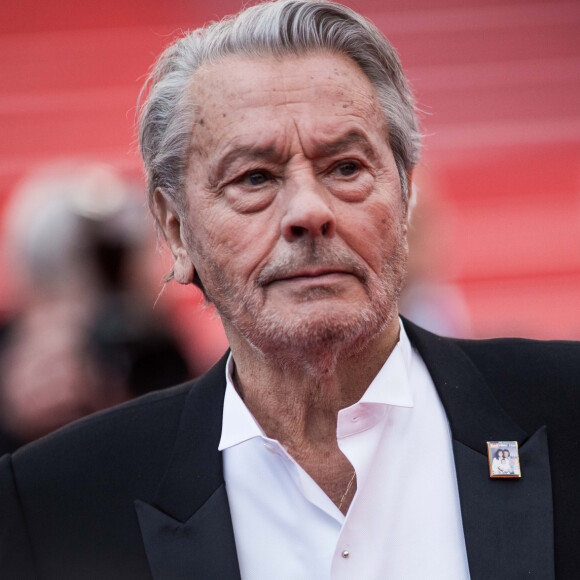 Nouveau rebondissement dans le tourbillon médiatique qui entoure Alain Delon et son clan. Après les douloureuses révélations du Parisien, s'appuyant sur des extraits de l'audition du Samouraï.
Alain Delon (avec un badge Paris Match d'une ancienne couverture du magazine titrant "Alain Delon, mes deux amours, Rosalie et Anouchka) - Montée des marches du film "A Hidden Life" lors du 72ème Festival International du Film de Cannes. © Jacovides-Moreau / Bestimage
