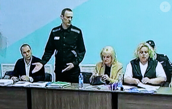 L'opposant russe Alexeï Navalny est accusé d'avoir créé une organisation extrémiste lors de son procès à Melekhovo (Russie), entouré de ses avocats, le 19 juin 2023. Dans une salle attenante, les parents de l'accusé, Anatoly et Lyudmila, suivent le procès.