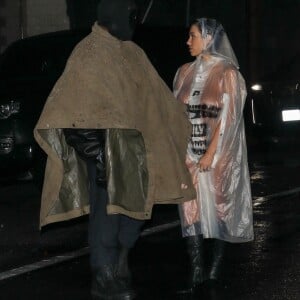 Exclusif - Kanye West, portant un masque intégral et un poncho, avec sa femme Bianca Censori, nue en imperméable transparent, arrivent à un studio à Los Angeles, le 5 février 2024. 
