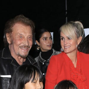 Johnny Hallyday, sa femme Laeticia (en béquilles) et leurs filles Jade et Joy au vernissage de l'exposition du photographe Mathieu Cesar à Los Angeles. Le 21 février 2017 