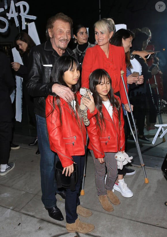 Johnny Hallyday, sa femme Laeticia (en béquilles) et leurs filles Jade et Joy au vernissage de l'exposition du photographe Mathieu Cesar à Los Angeles. Le 21 février 2017 