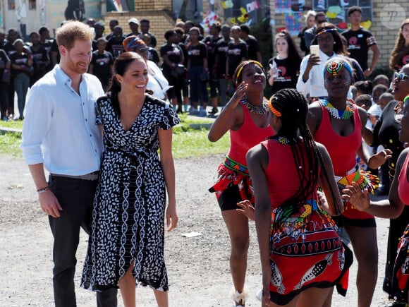 Meghan Markle, duchesse de Sussex, et le prince Harry, duc de Sussex, en visite dans le township de Nyanga, Afrique du Sud. Le 23 septembre 2019. Leur premier rendez-vous en Afrique du Sud est une initiative du Justice Desk de Nyanga. Cette ONG enseigne aux enfants leurs droits et leur sécurité. Elle propose des cours d'auto-défense et une formation à l'autonomie des femmes pour les jeunes filles de la communauté. Le Justice Desk est soutenu par le Queen's Commonwealth Trust dont le duc de Sussex est président et la duchesse vice-présidente. Jusque là, le bureau a aidé environ 35 000 personnes. Le duc et la duchesse ont fait le tour à pied des diverses activités proposées par le Justice Desk. 