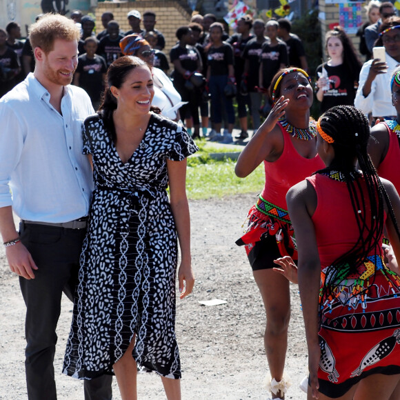 Meghan Markle, duchesse de Sussex, et le prince Harry, duc de Sussex, en visite dans le township de Nyanga, Afrique du Sud. Le 23 septembre 2019. Leur premier rendez-vous en Afrique du Sud est une initiative du Justice Desk de Nyanga. Cette ONG enseigne aux enfants leurs droits et leur sécurité. Elle propose des cours d'auto-défense et une formation à l'autonomie des femmes pour les jeunes filles de la communauté. Le Justice Desk est soutenu par le Queen's Commonwealth Trust dont le duc de Sussex est président et la duchesse vice-présidente. Jusque là, le bureau a aidé environ 35 000 personnes. Le duc et la duchesse ont fait le tour à pied des diverses activités proposées par le Justice Desk. 