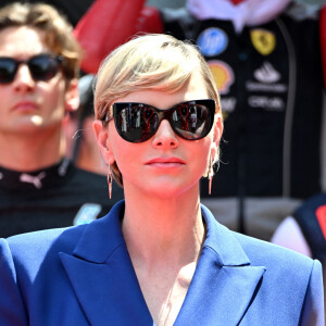 Elle a choisi de porter un tailleur bleu electrique et des boucles d'oreille de la marque Louis Vuitton assortie à sa paire de lunettes de soleil. 
La princesse Charlène de Monaco pendant les hymnes lors du Grand Prix de Formule 1 (F1) de Monaco, le 26 mai 2024. © Bruno Bebert/Bestimage