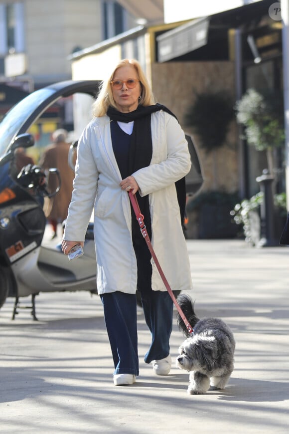 Sylvie Vartan, très souriante, pose pour les photographes à la sortie de l'institut de beauté Carlota avec son chauffeur et son chien Muffin à Paris, le 16 février 2018. 