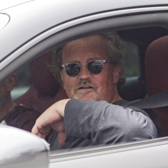 Matthew Perry se balade avec un ami au volant de sa Porsche Taycan à Los Angeles, le 27 avril 2023