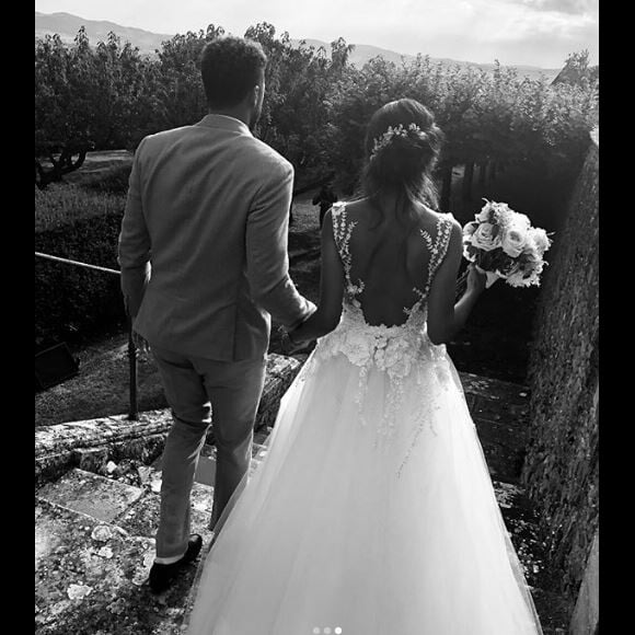 Une longue robe de mariée avec décolletée devant mais aussi dans le dos

Noura, la femme de Jo-Wilfried Tsonga dévoile des photos de leur mariage sur Instagram le 23 juillet 2018.