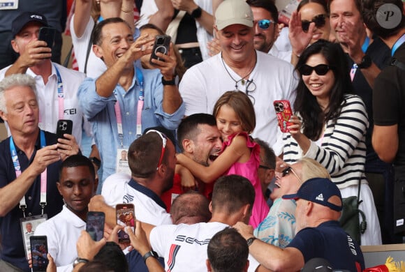 Le Serbe Novak Djokovic tient sa fille dans ses bras après avoir remporté la médaille d'or lors de son match de finale du simple messieurs contre l'Espagnol Carlos Alcaraz à Roland Garros lors de la neuvième journée des Jeux Olympiques de Paris, le dimanche 04 août 2024.