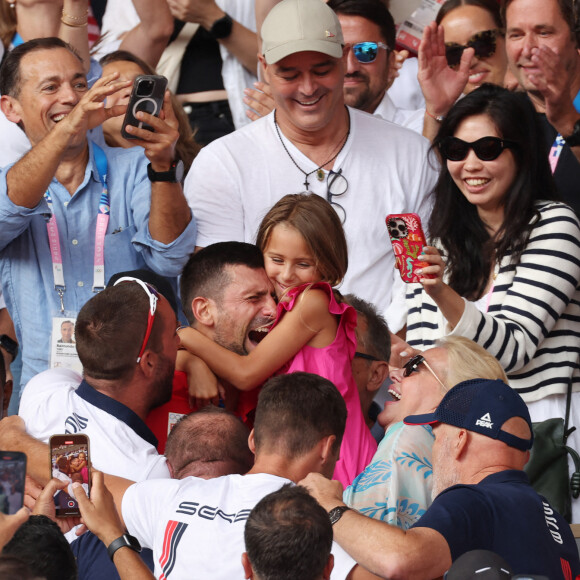 Le Serbe Novak Djokovic tient sa fille dans ses bras après avoir remporté la médaille d'or lors de son match de finale du simple messieurs contre l'Espagnol Carlos Alcaraz à Roland Garros lors de la neuvième journée des Jeux Olympiques de Paris, le dimanche 04 août 2024.