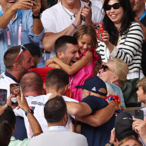 Le Serbe Novak Djokovic tient sa fille dans ses bras après avoir remporté la médaille d'or lors de son match de finale du simple messieurs contre l'Espagnol Carlos Alcaraz à Roland Garros lors de la neuvième journée des Jeux Olympiques de Paris, le dimanche 04 août 2024.