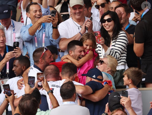 Le Serbe Novak Djokovic tient sa fille dans ses bras après avoir remporté la médaille d'or lors de son match de finale du simple messieurs contre l'Espagnol Carlos Alcaraz à Roland Garros lors de la neuvième journée des Jeux Olympiques de Paris, le dimanche 04 août 2024.