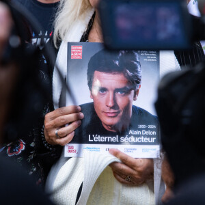 Les fans rendent hommage à Alain Delon devant la grille de sa propriété à Douchy-Montcorbon pendant ses obsèques le 24 août 2024. © Baptiste Autissier / Panoramic / Bestimage 