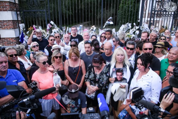 Les fans rendent hommage à Alain Delon à 17 heures en chantant la chanson "Paroles Paroles" avec la pluie qui arrive juste à la fin comme un signe devant la propriété de l'acteur au moment de ses obsèques à Douchy-Montcorbon le 24 août 2024. © Baptiste Autissier / Panoramic / Bestimage