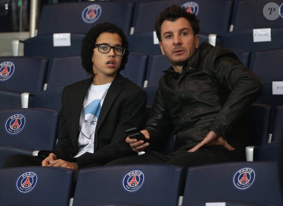 Michaël Youn et son beau-fils Sean (fils de Pascal Obispo et isabelle Funaro) (T-shirt Cara Delevingne Maison Seine c/o Colette) - People assistent au match de football PSG contre Monaco au Parc des Princes à Paris le 5 octobre 2014. Le match s'est soldé par un match nul 1-1