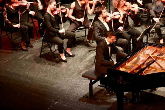 "Je suis autodidacte. A Tripoli, ma ville natale au nord du Liban, il n'y avait pas d'école de musique, donc j'ai commencé le piano seul, et je compose à l'oreille depuis tout petit. Ensuite, à 17 ans, j'ai gagné un concours organisé par l'Union Soviétique de Gorbatchev."
Le compositeur et pianiste de renommée internationale Omar Harfouch a joué en première mondiale sa nouvelle création "Concerto pour la paix" avec l'Orchestre Méditerranéen de Béziers, composé de 43 musiciens et du chef d'orchestre Mathieu Bonin, accompagné au violon par la célèbre violoniste Anne Gravoin © Daniel Topic via Bestimage