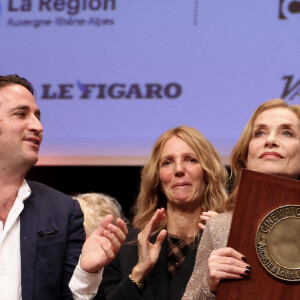 Isabelle Huppert avec ses fils Lorenzo Chammah et Angelo Chammah pendant la cérémonie de remise du prix lumière à I.Huppert lors de la 16ème édition du Festival Lumière à l'Amphithéâtre - Centre de Congrès à Lyon, France, le 18 octobre 2024. © Dominique Jacovides/Bestimage 