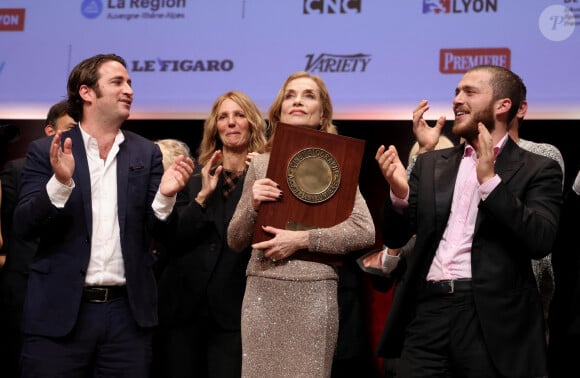 Isabelle Huppert avec ses fils Lorenzo Chammah et Angelo Chammah pendant la cérémonie de remise du prix lumière à I.Huppert lors de la 16ème édition du Festival Lumière à l'Amphithéâtre - Centre de Congrès à Lyon, France, le 18 octobre 2024. © Dominique Jacovides/Bestimage 