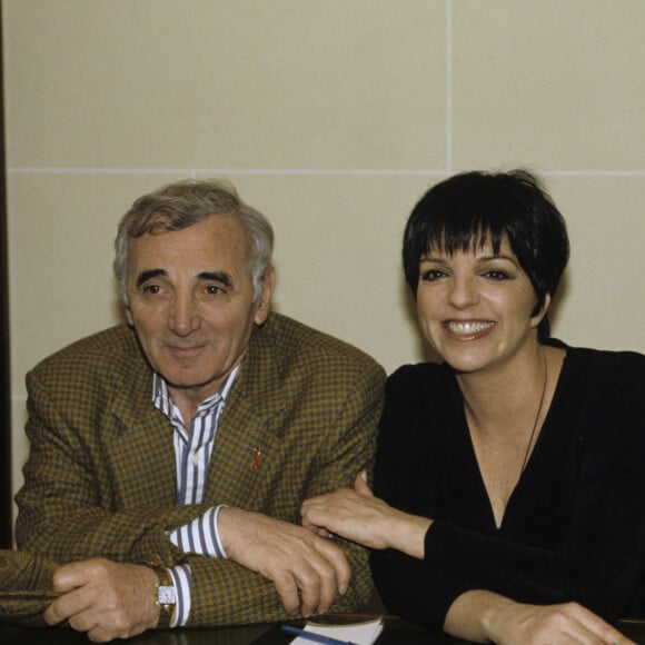 Archives - En France, à Paris - Charles Aznavour et Liza Minnelli, ensemble, assis devant une table. Le 7 avril 1994 © Alain Canu via Bestimage