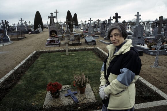 Archives - En France, à Cellier, Jeanne De Funès devant la tombe de son mari Louis de Funès le 18 décembre 1983.