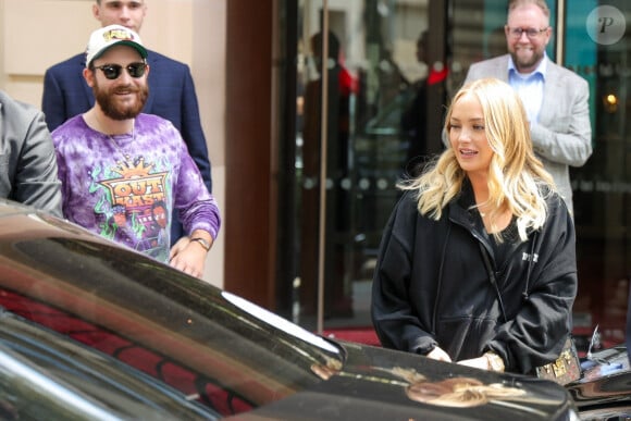 René-Charles Angélil, porte un t-shirt Outkast, et sa compagne Angelique Weckenmann à la sortie de l'hôtel Royal Monceau avant l'ouverture des Jeux Olympiques (JO) Paris 2024 à à Paris, France, le 24 juillet 2024. 