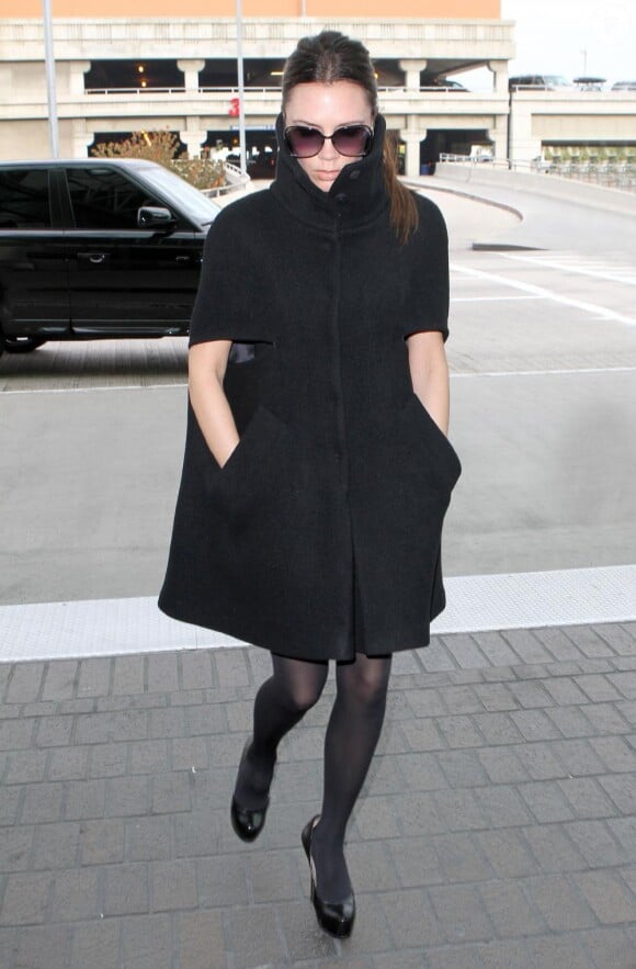 Victoria Beckham dans une cape noire avec un look étudié et total black
