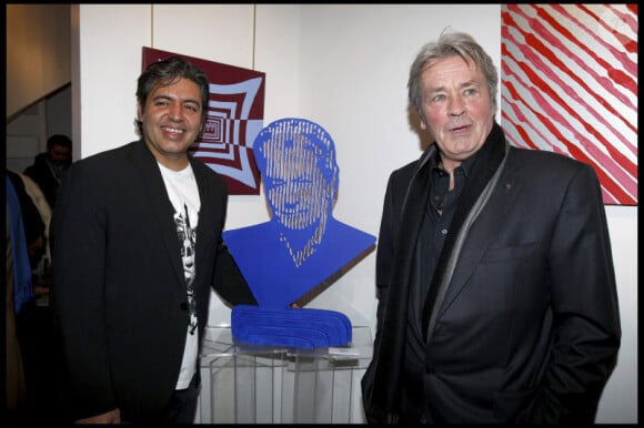 Alain Delon, avec l'artiste Marcos Marin, lors du vernissage de l'exposition de Marcos Marin sur les "Icônes du XXe siècle" à la galerie Caplain-Matignon à Paris le 24 janvier 2011