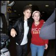 Justin Bieber arrive à l'aéroport de Londres-Heathrow, jeudi 3 mars, et prend le temps de faire quelques photos avec ses fans venus l'accueillir sur place.