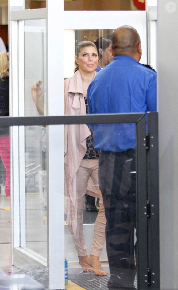 Fergie, à l'aéroport de Los Angeles, se fait fouiller par un agent au sol, lors de son passage au contrôle de sécurité. 17 avril 2011