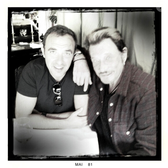 Johnny Hallyday et Nikos Aliagas posent au restaurant Le Murat, à Paris, le 10 mai 2011.