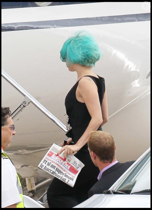 Lady Gaga, un exemplaire du Parisien dans la main, monte dans son jet à l'aéroport du Bourget, direction le Canada. Le 16 juin 2011.