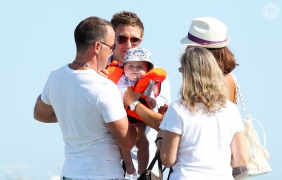 Elton John et David Furnish à Saint-Tropez le 18 août 2011, arrivant au club 55 : leur bébé enfile son gilet de sauvetage