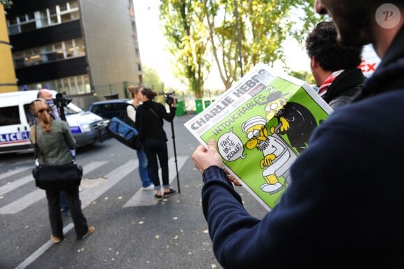 French satirical weekly Charlie Hebdo and journalists pictured in front the headquarters near a police car, Paris, France on September 19, 2012 the last issue which features on the front cover a satirical drawing entitled "Intouchables 2". Inside pages contain several cartoons caricaturing the Prophet Mohammed. Photo by Mousse/ABACAPRESS.COM19/09/2012 - Paris