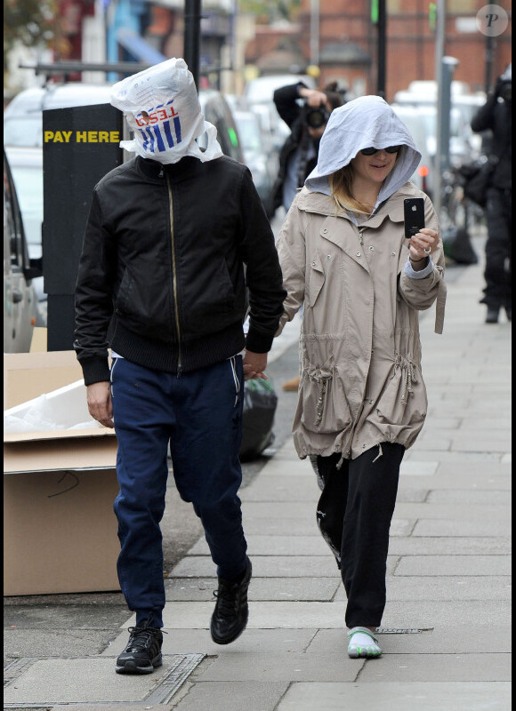 Matthew Bellamy et Kate Hudson tentent d'échapper aux paparazzi en enfilant un sac plastique sur la tête le 1er décembre 2011