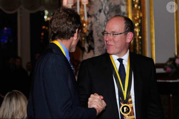 Le prince Albert de Monaco félicite son neveu Andrea Casiraghi lors de son intronisation au sein de l'ordre de la Chope d'Or le 12 décembre 2011 à l'hôtel de Paris à Monaco
