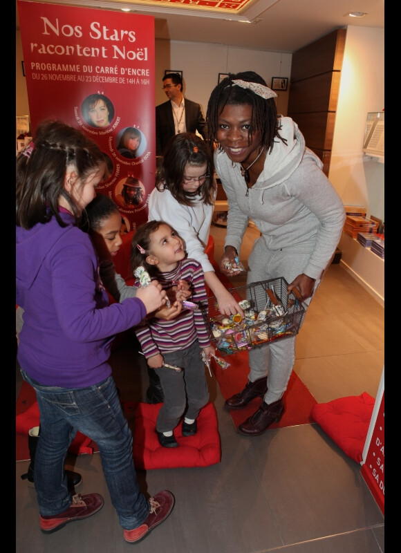 Princess Erika distribue les bonbons aux enfants à la fin de la lecture d'un conte de Noël le 14 décembre 2011 à la librairie Carré d'Encre à Paris