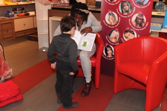 Princess Erika s'entretient avec un petit garçon lors de la lecture d'un conte de Noël le 14 décembre 2011 à la librairie Carré d'Encre à Paris