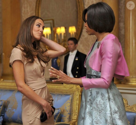 Kate Middleton, rencontre avec les Obama à Buckingham le 25 mai 2011.
Pour sa première année dans la famille royale, Catherine, duchesse de Cambridge, a donné à observer, dans le spectacle de son élégance, un petit geste très coquet : le recoiffage !