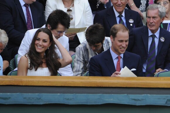 Kate Middleton à Wimbledon le 27 juin 2011.
Pour sa première année dans la famille royale, Catherine, duchesse de Cambridge, a donné à observer, dans le spectacle de son élégance, un petit geste très coquet : le recoiffage !