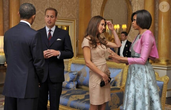 Kate Middleton, rencontre avec les Obama à Buckingham le 25 mai 2011.
Pour sa première année dans la famille royale, Catherine, duchesse de Cambridge, a donné à observer, dans le spectacle de son élégance, un petit geste très coquet : le recoiffage !