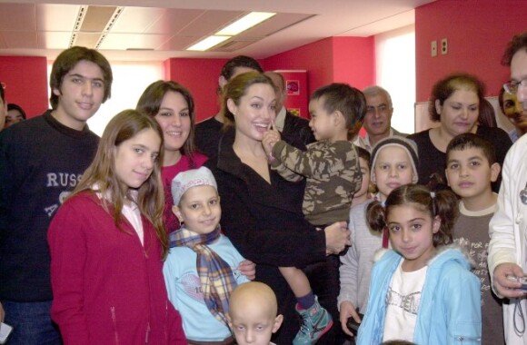 Angelina Jolie à Beyrouth au Liban dans un centre pour enfants malades du cancer, en décembre 2004. Elle pose avec son fils Maddox