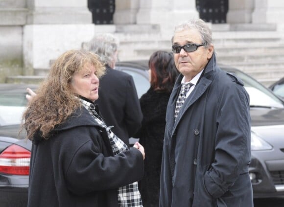 Pierre Perret et sa femme lors des obsèques de la productrice Brigitte Kido au crématorium du Père-Lachaise à Paris le 1er mars 2012