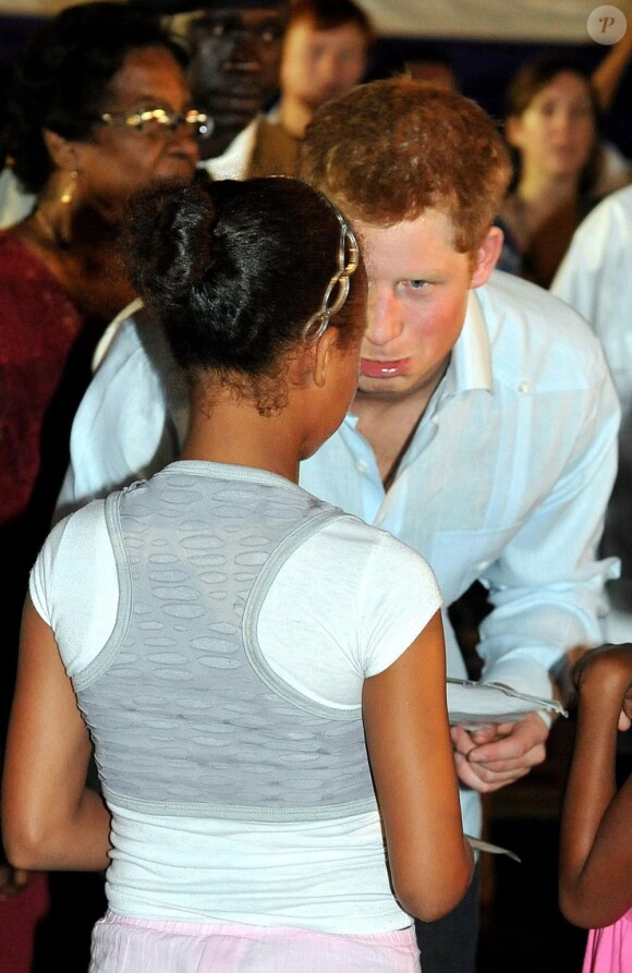 Le Prince Harry console une petite fille à Belmopan, au Belize, le 2 mars 2012
